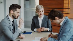 Business people signing a contract at a table