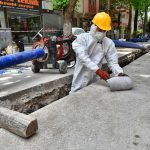 a man wearing a protective suit and a hard hat working on a street